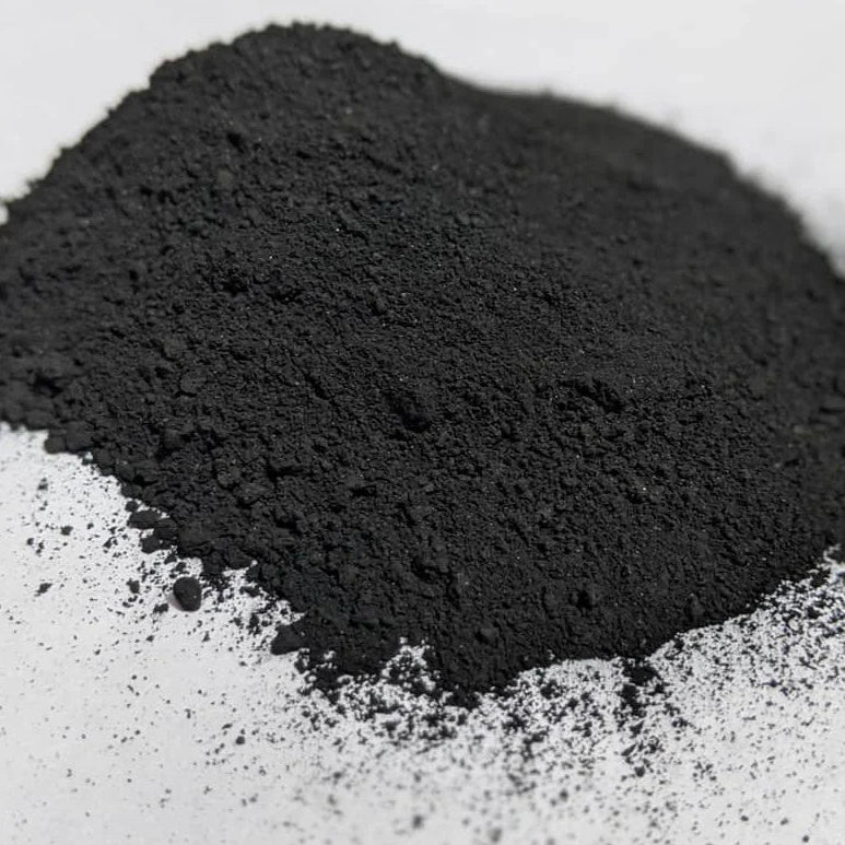 Pile of black activated charcoal powder on a white background