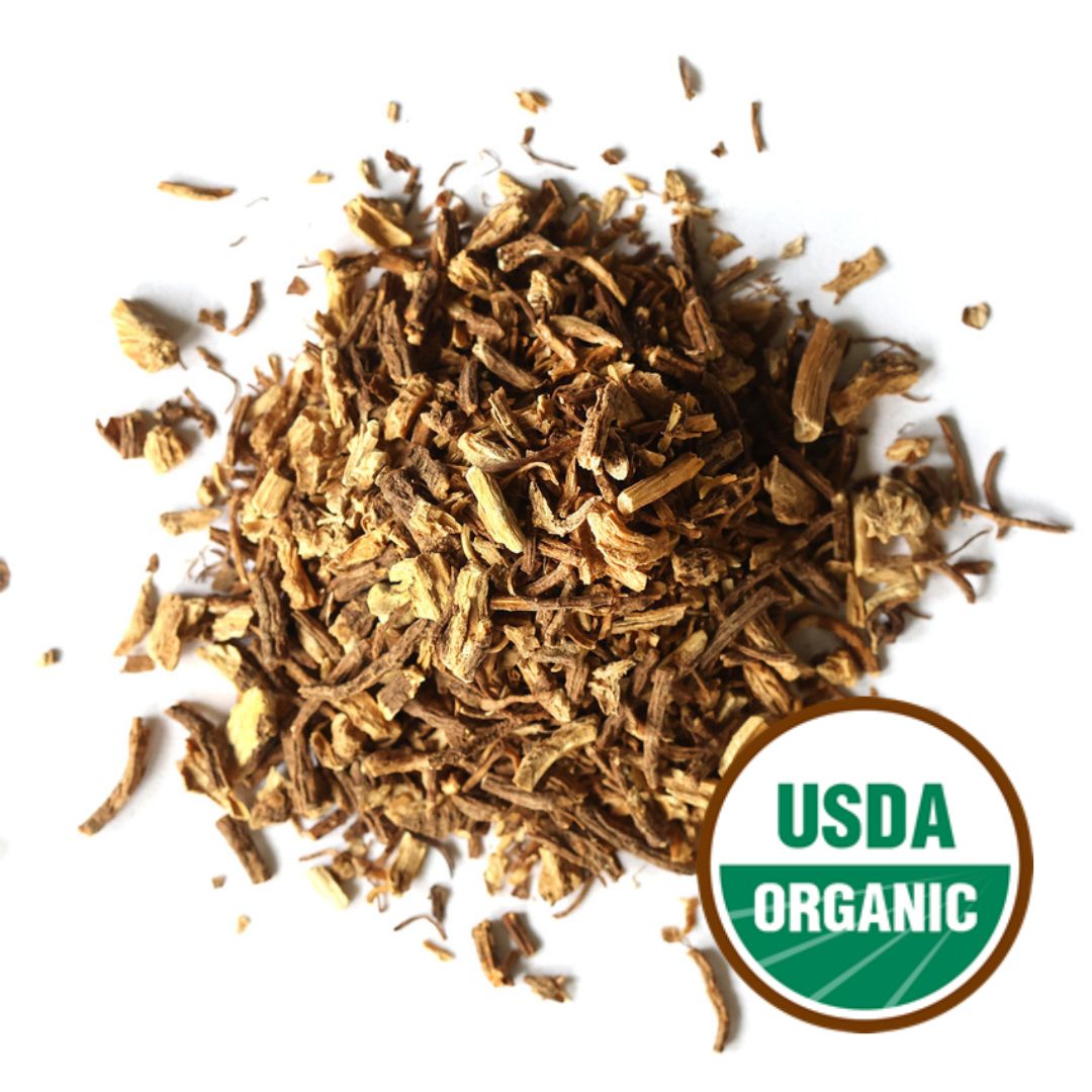 Heap of dried angelica root pieces with USDA Organic label on a white background